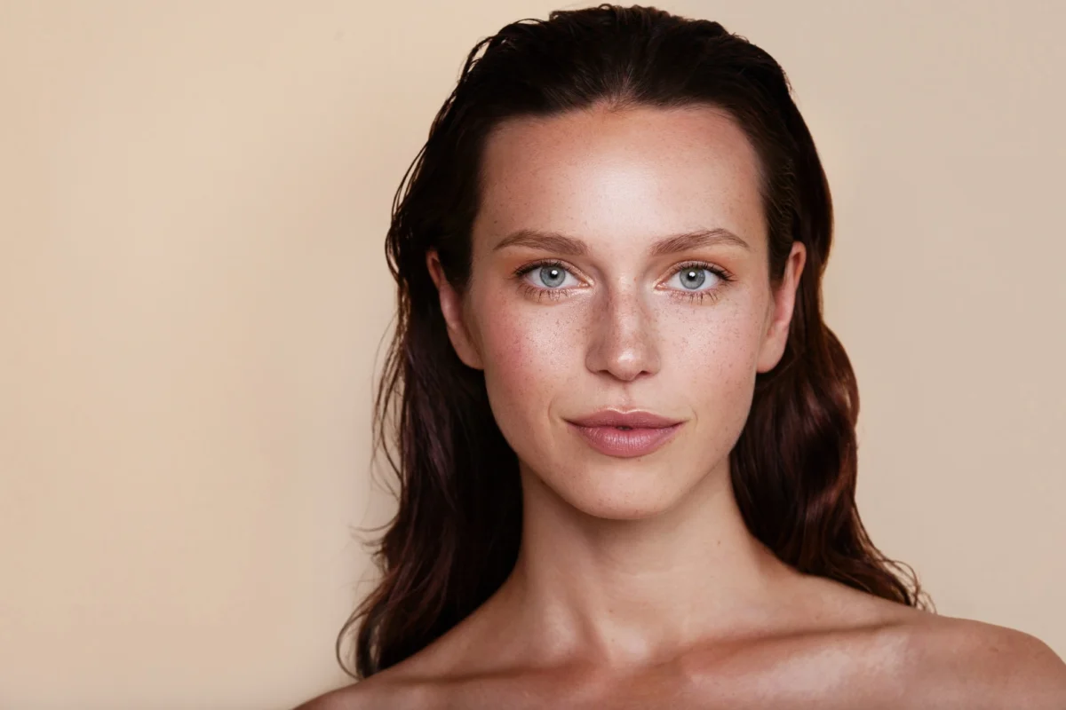 a woman with long hair and a radiant face with medical aesthetic treatments