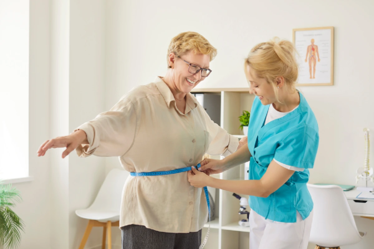 Patient measuring weight loss progress during a medical weight loss program at The Confidence Collective.