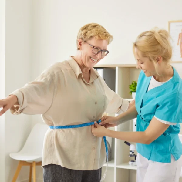 Patient measuring weight loss progress during a medical weight loss program at The Confidence Collective.